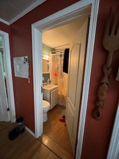 bathroom featuring ornamental molding, vanity, hardwood / wood-style floors, and toilet