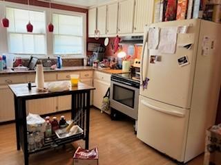 kitchen with light wood-type flooring, range, and white refrigerator