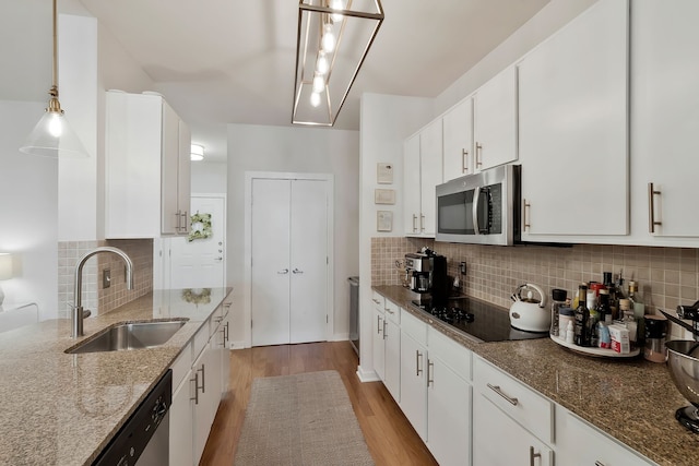 kitchen with sink, tasteful backsplash, white cabinetry, and stainless steel appliances