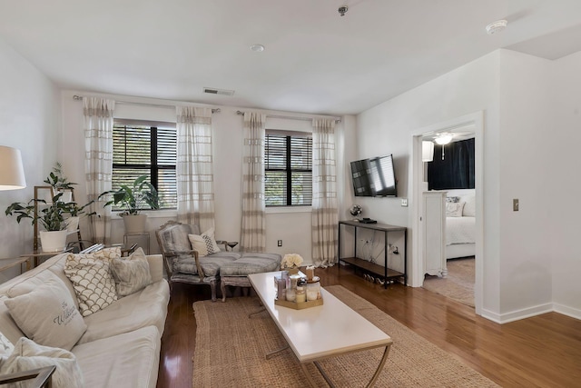 living room featuring a healthy amount of sunlight, dark wood-style floors, and visible vents