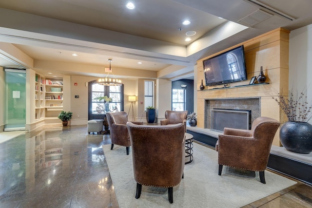 interior space featuring a chandelier, baseboards, plenty of natural light, and a tiled fireplace