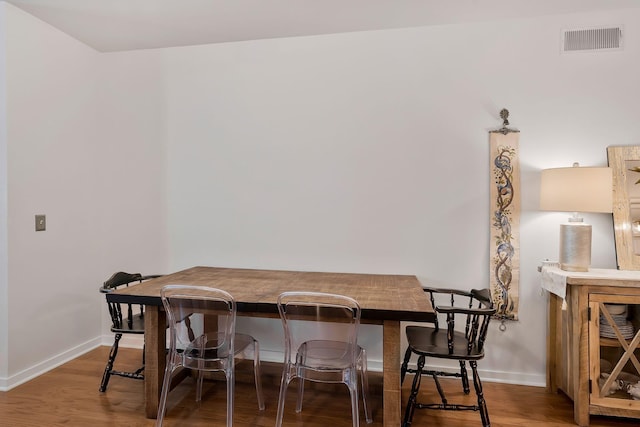 dining space featuring visible vents, baseboards, and wood finished floors