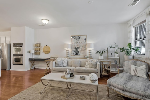 living room with dark wood-style floors and visible vents