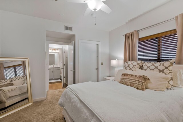 carpeted bedroom with ceiling fan and ensuite bathroom