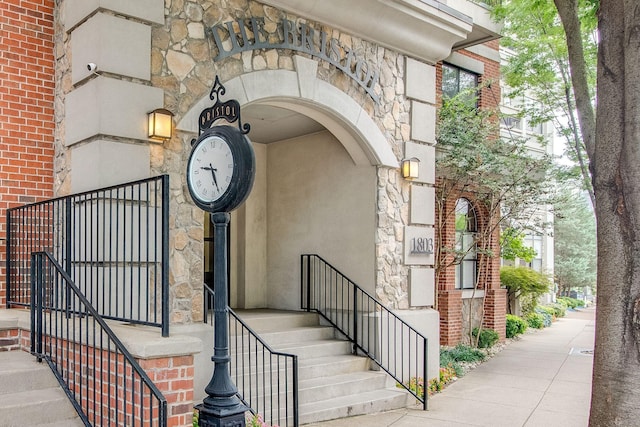 property entrance with stone siding, brick siding, and stucco siding