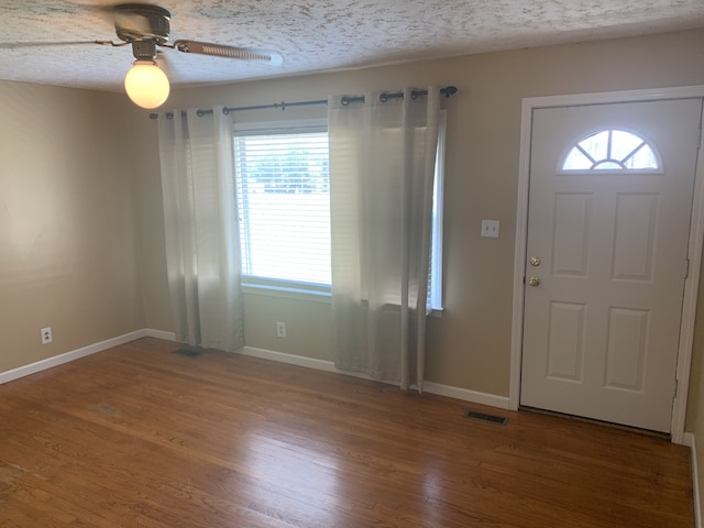 foyer featuring ceiling fan, hardwood / wood-style floors, and a textured ceiling