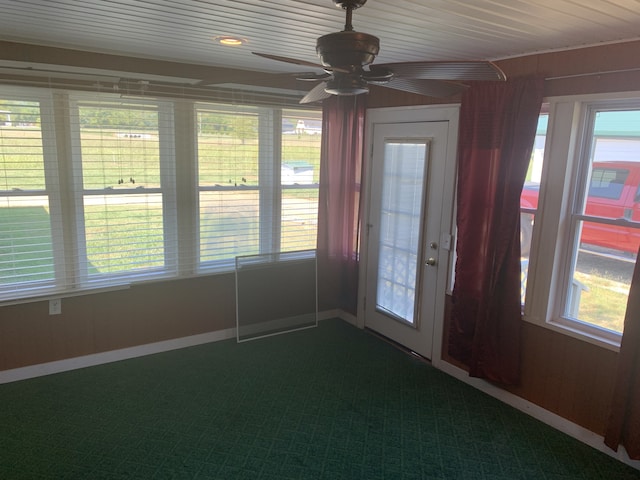 unfurnished sunroom featuring wood ceiling and ceiling fan