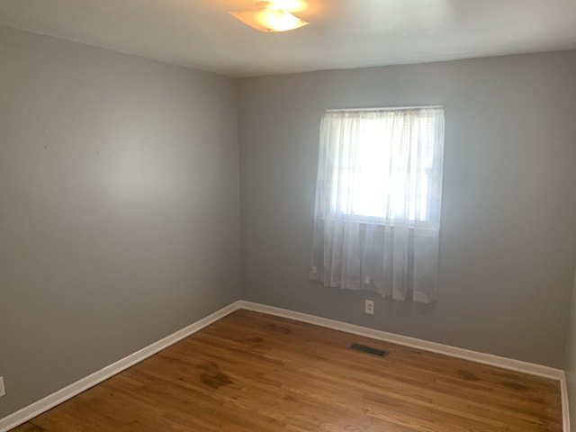 empty room with hardwood / wood-style floors