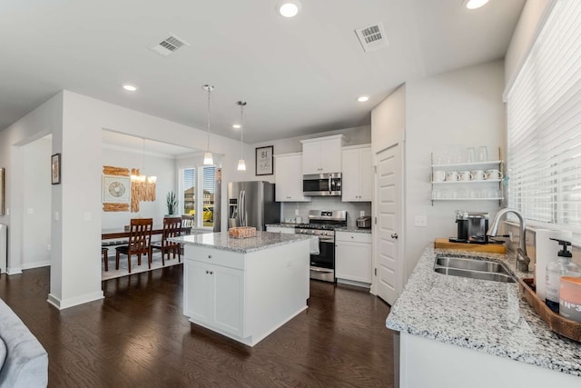 kitchen featuring white cabinetry, appliances with stainless steel finishes, dark wood-type flooring, and a kitchen island