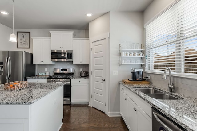 kitchen with sink, dark hardwood / wood-style flooring, appliances with stainless steel finishes, decorative backsplash, and white cabinets