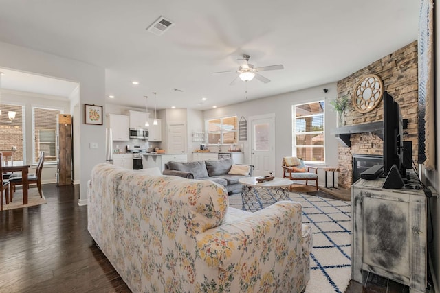 living room featuring hardwood / wood-style flooring, a fireplace, and ceiling fan