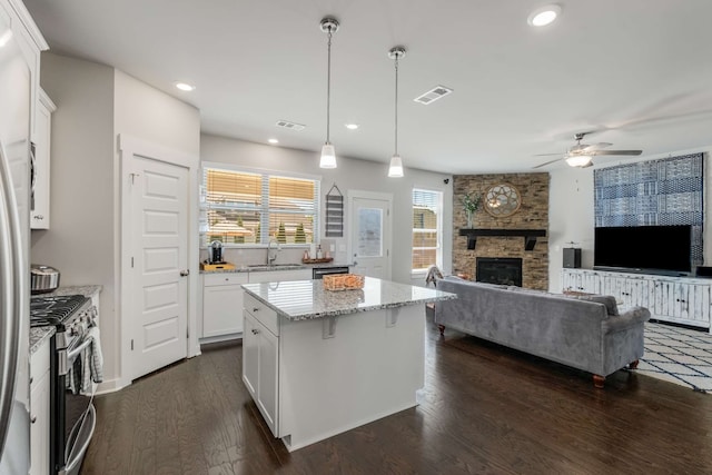 kitchen featuring white cabinets, a center island, dark hardwood / wood-style floors, and stainless steel appliances