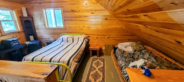 bedroom with multiple windows, vaulted ceiling, and wood walls