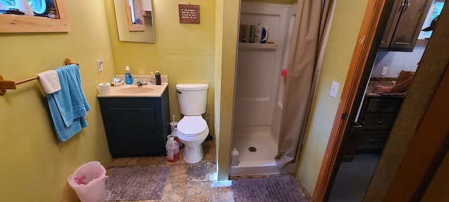 bathroom featuring tile patterned flooring, toilet, vanity, and walk in shower