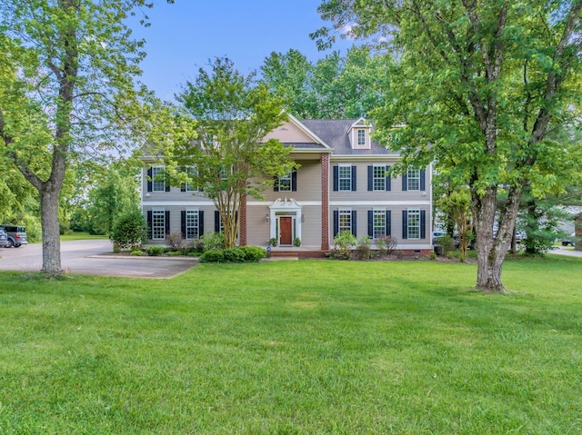 colonial-style house featuring a front yard