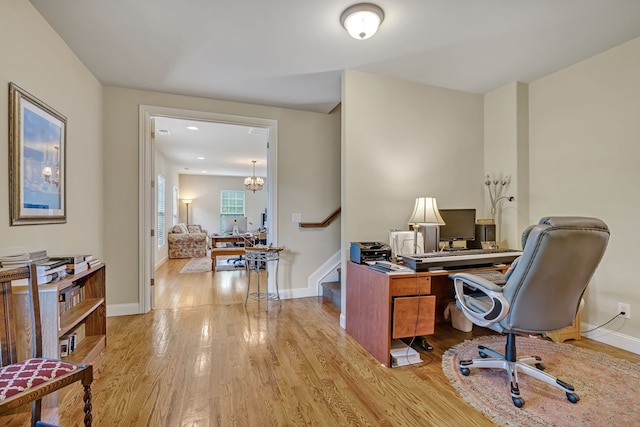 office featuring light hardwood / wood-style floors and an inviting chandelier