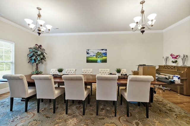 dining area featuring dark wood-type flooring, a notable chandelier, and ornamental molding