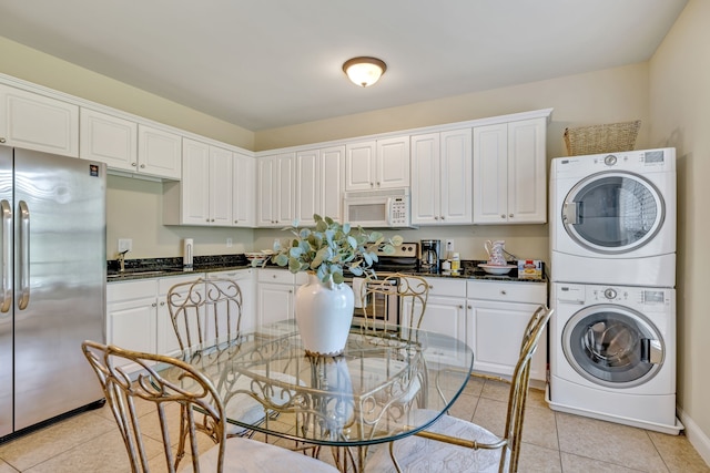 washroom with stacked washer and clothes dryer and light tile patterned floors