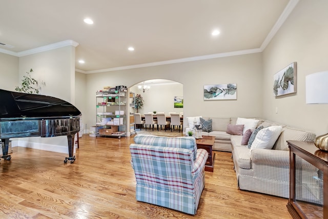 living room featuring light hardwood / wood-style floors, ornamental molding, and a chandelier