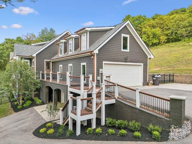 back of property with a garage, a yard, and a wooden deck