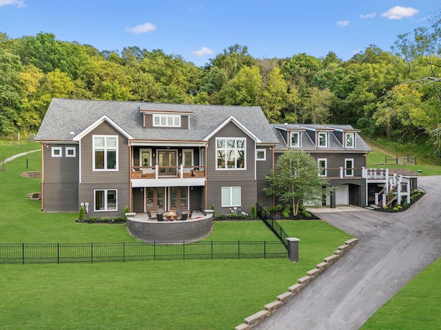 view of front facade featuring a garage, a front lawn, and a balcony