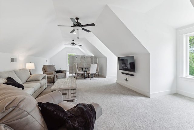 carpeted living room with ceiling fan, a wealth of natural light, and lofted ceiling