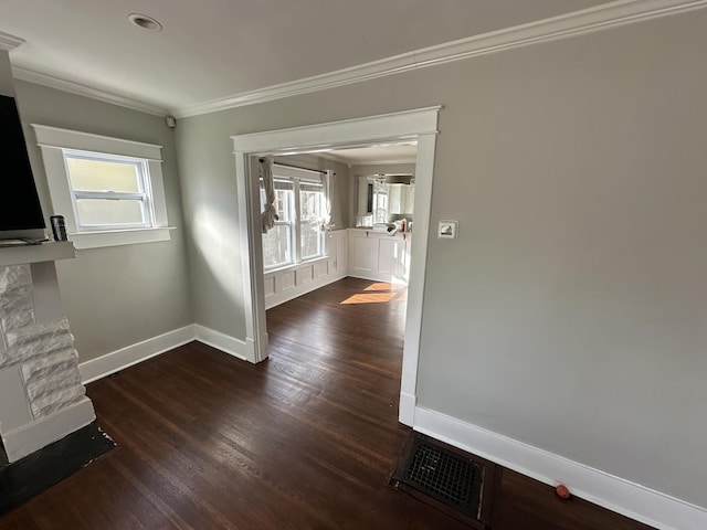 interior space featuring visible vents, plenty of natural light, ornamental molding, and dark wood-style flooring