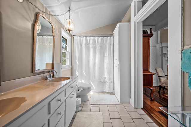 bathroom with double vanity, a shower with shower curtain, toilet, tile patterned floors, and a sink