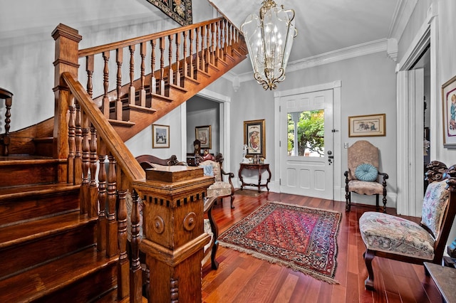 entrance foyer featuring crown molding, wood finished floors, stairs, and a notable chandelier