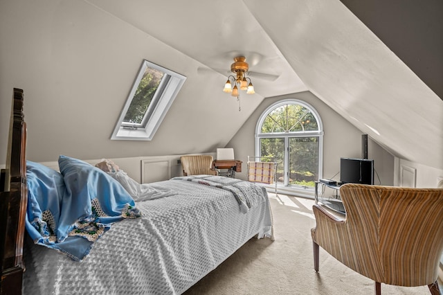 carpeted bedroom with vaulted ceiling with skylight and ceiling fan