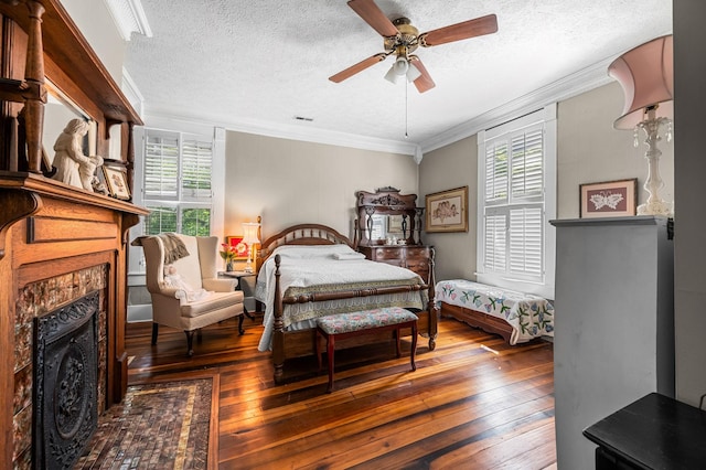 bedroom featuring hardwood / wood-style flooring, a fireplace, crown molding, and a textured ceiling