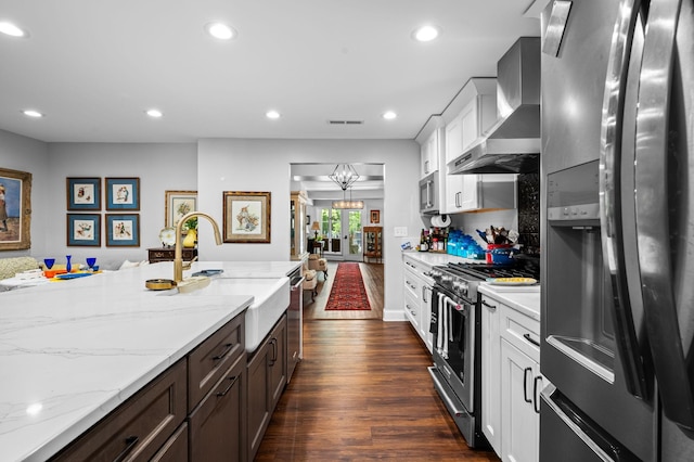 kitchen with recessed lighting, stainless steel appliances, dark wood-type flooring, a sink, and wall chimney exhaust hood