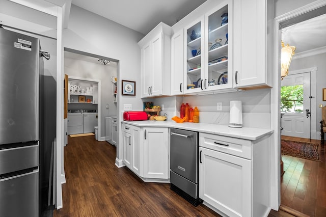 kitchen with dark wood-style flooring, white cabinets, freestanding refrigerator, washer and clothes dryer, and glass insert cabinets