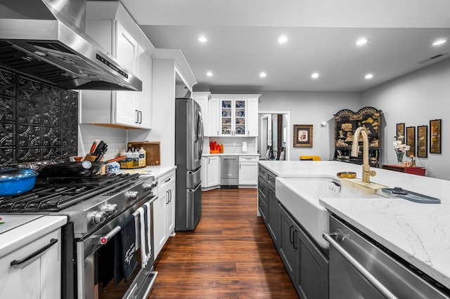 kitchen with recessed lighting, stainless steel appliances, visible vents, white cabinetry, and wall chimney range hood