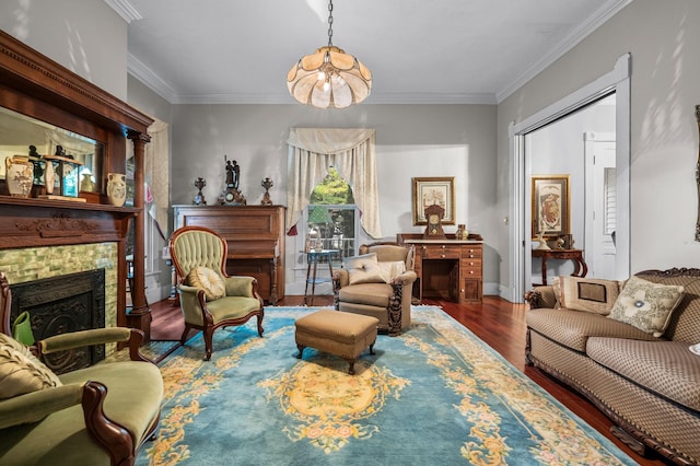 living room with a notable chandelier, a fireplace, ornamental molding, wood finished floors, and baseboards