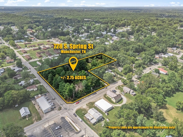 birds eye view of property featuring a forest view