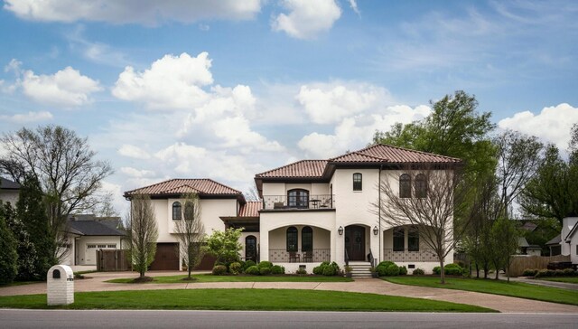 mediterranean / spanish home with a balcony and a front yard