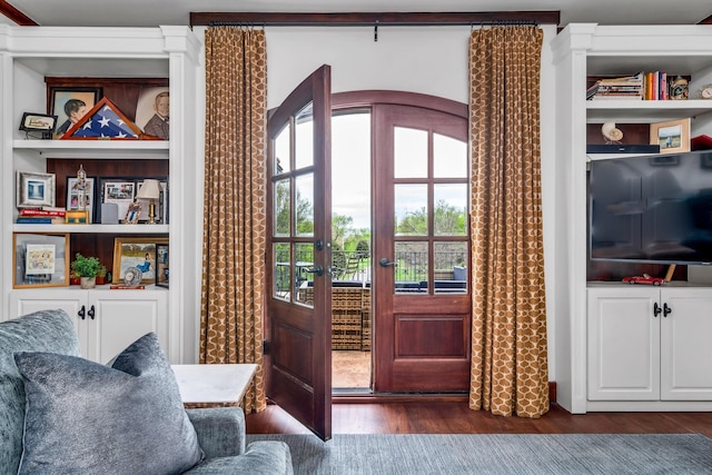 doorway to outside featuring dark wood-style floors and built in features