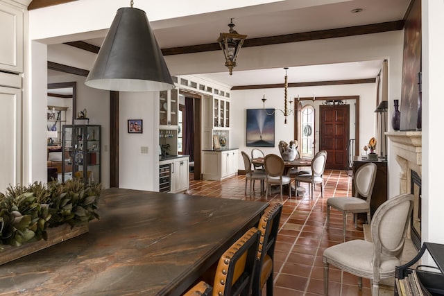 dining area with wine cooler, a fireplace, beamed ceiling, and dark tile patterned flooring