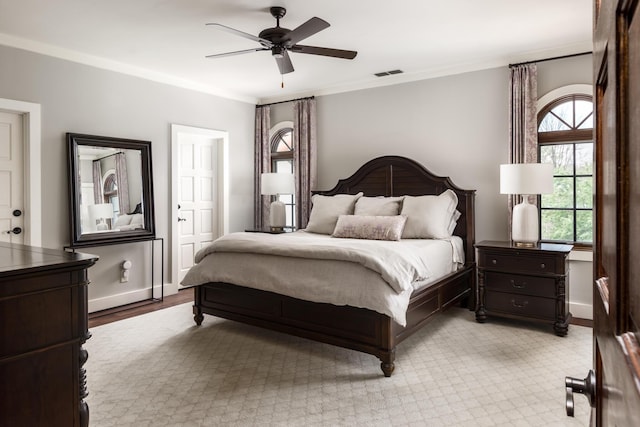 bedroom with visible vents, ornamental molding, ceiling fan, and baseboards