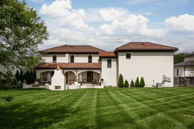 rear view of property with a patio area, a yard, and central AC unit