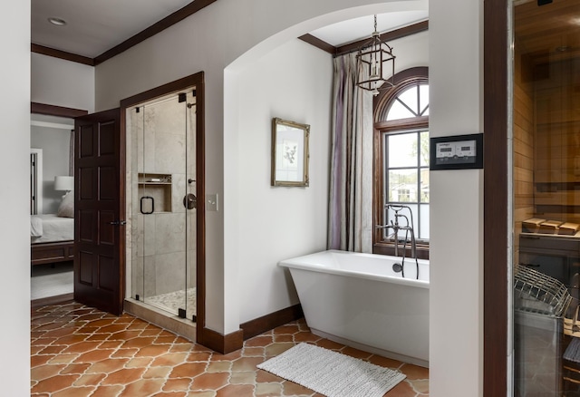 bathroom featuring crown molding, a shower stall, ensuite bath, a freestanding tub, and baseboards