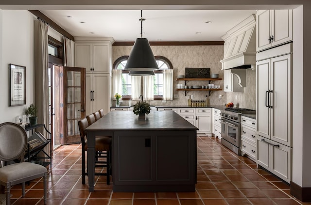 kitchen with decorative backsplash, premium appliances, a kitchen island, a breakfast bar, and pendant lighting