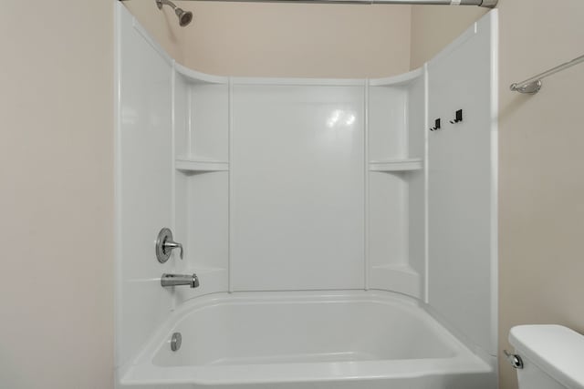 bathroom with bathtub / shower combination and toilet