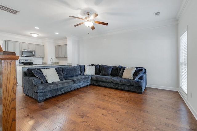 living room featuring hardwood / wood-style floors, sink, ornamental molding, and ceiling fan