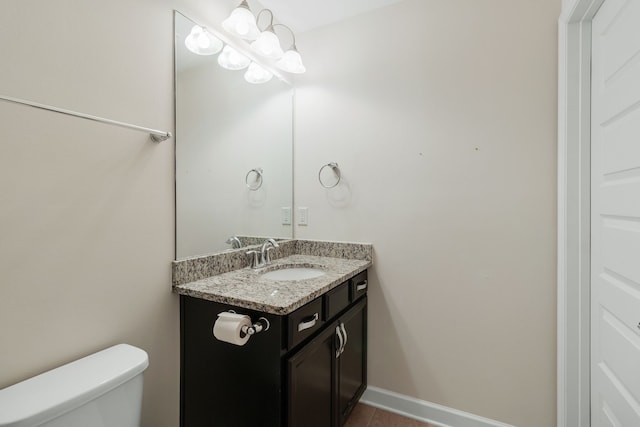 bathroom featuring tile patterned floors, toilet, vanity, and an inviting chandelier