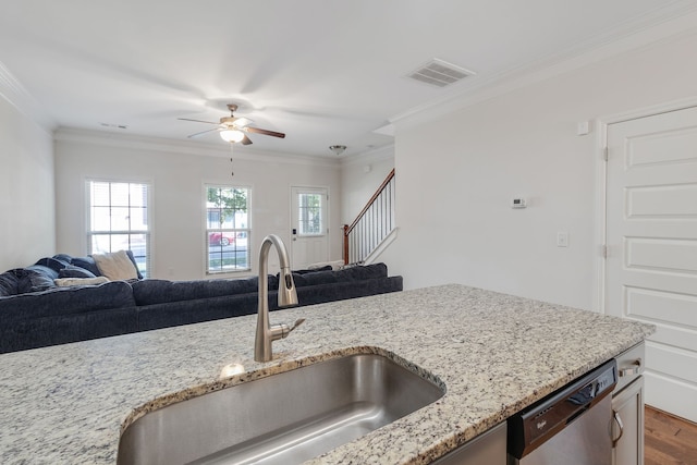 kitchen featuring sink, plenty of natural light, stainless steel dishwasher, and light stone countertops