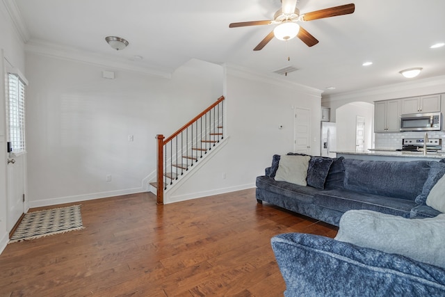 living room featuring hardwood / wood-style flooring, ornamental molding, and ceiling fan