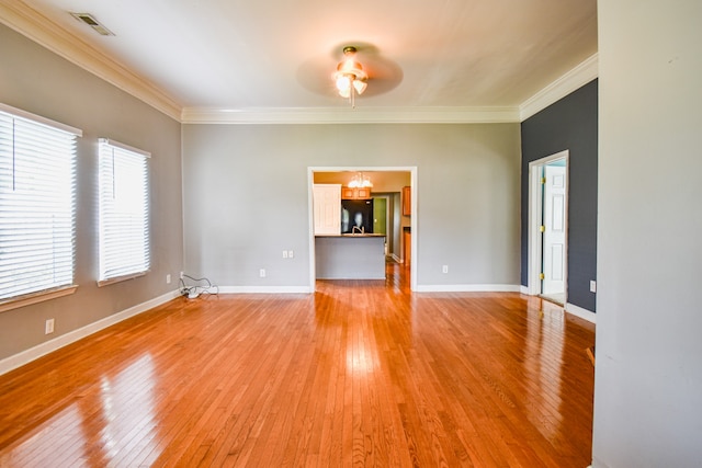 empty room with ornamental molding, hardwood / wood-style flooring, and ceiling fan