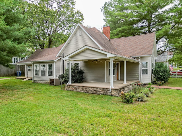 rear view of house with ceiling fan, a lawn, and a patio area